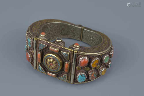 A Tibetan metal bracelet with various stone inserts.