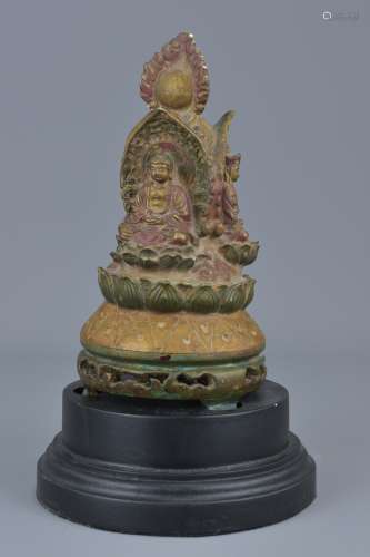 A Tibetan wooden pagoda carved with three Buddhas on display stand. 24cm height