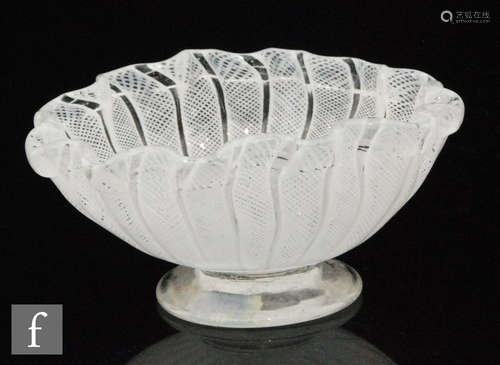 A 19th Century glass bowl of footed form with wavy rim decorated with white latticino flat laid