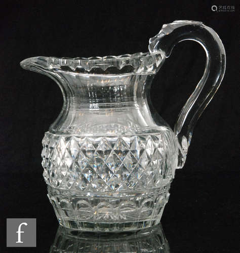 An early 19th Century clear crystal jug of ovoid form with an applied loop handle and thumb flat,