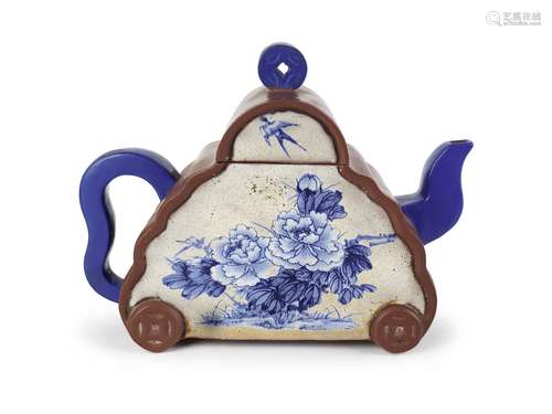 A BLUE AND WHITE TEAPOT IN THE SHAPE OF A CAR