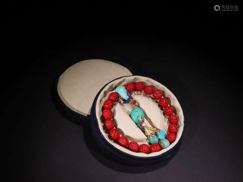 A RED LACQUER WOOD BRACELET WITH TURQUOISE STONE