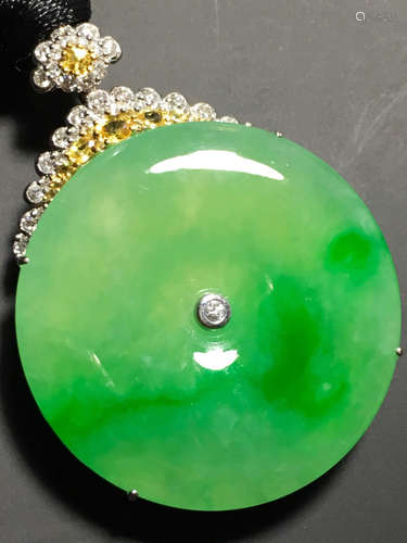 A GREEN JADEITE CARVED CIRCLE PENDANT, TYPE A