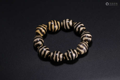 AN OLD DALLO DZI STRING BRACELET