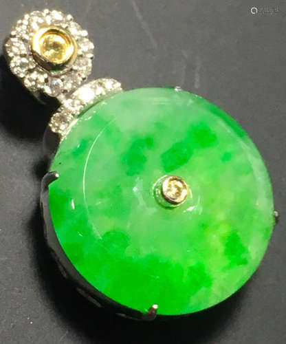 A GREEN JADEITE CARVED CIRCLE PENDANT, TYPE A