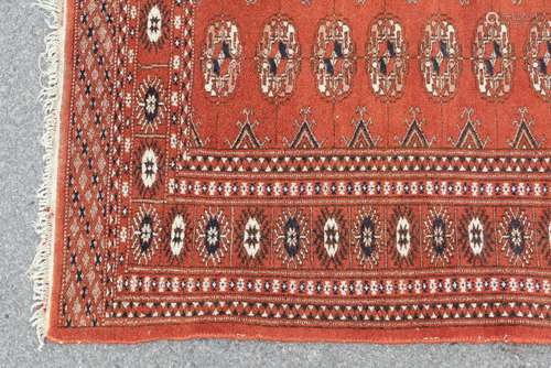 A Turkish Wool Carpet, terracotta ground with geometric design heightened with blue and cream medallions, approx 140 x 95 cms, selvedges and tassels slightly imperfect