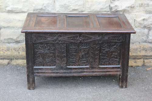 An 18th Century Oak Coffer, with panelled front and top with decorative carving, approx 96w x 53d x 63h cms