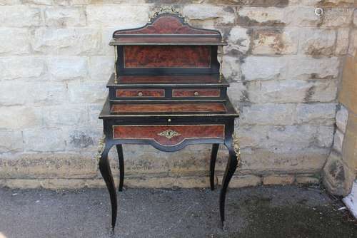 A Louis XV Style Ebonised and Burr Walnut Desk: the three tier desk comprises pull out slide, single drawer beneath two small drawers, shelf gallery above, brass fixtures, approx 71 x 50 x 124 cms