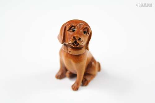 A Japanese Boxwood Netsuke, carved in the form of a seated dog, approx 45 mm, signed to base