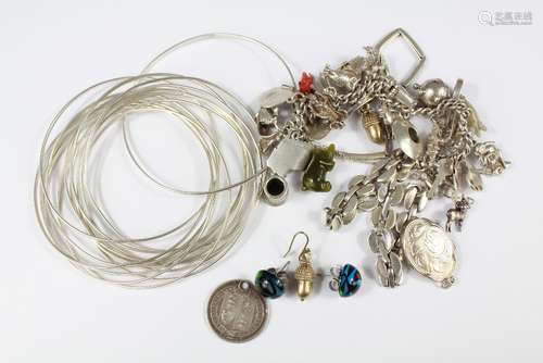 Miscellaneous Silver Jewellery: this lot includes charm bracelet (25 charms), fourteen bangles, two silver bracelets, acorn earrings and glass earrings, locket and Victorian silver coin, approx 177 gms