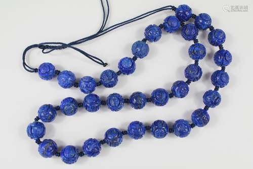 A String of Chinese Lapis Lazuli Carved Beads, the individual beads carved with a floral design, approx 48 cms l