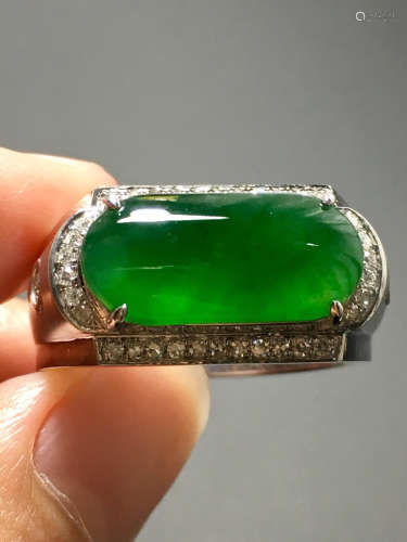 AN ICY GREEN JADEIET RING IN SADDLE CARVED