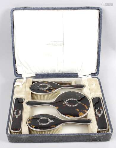 A 1920's cased tortoiseshell and silver mounted dressing table set,