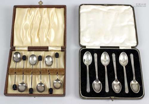 Two cased sets of silver coffee spoons,