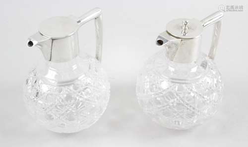 A near pair of turn of the century silver mounted claret jugs,