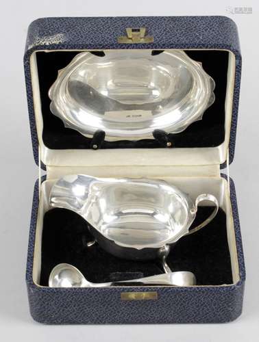 A twentieth century cased set of sauce boat and stand,