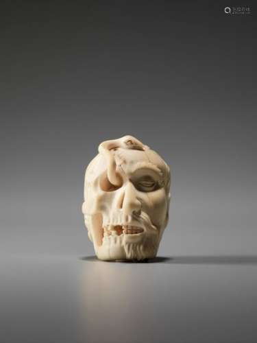 AN IVORY CARVING OF A SKULL AND SNAKE