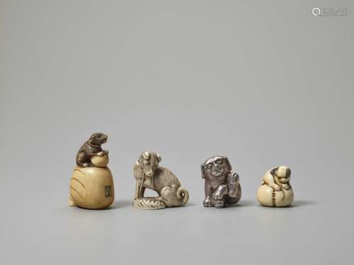 ONE SILVER AND THREE IVORY NETSUKE OF DOGS