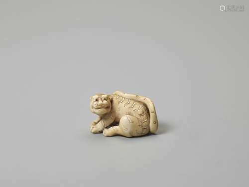 AN IVORY NETSUKE OF A TIGER