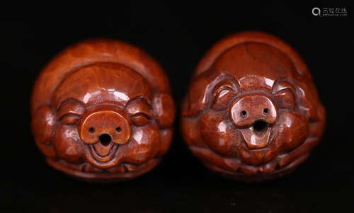 A PAIR OF WALNUT  PIG SHAPED ORNAMENT