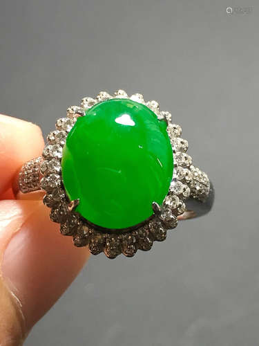 A GREEN JADEITE CARVED CIRCLE FINGER RING