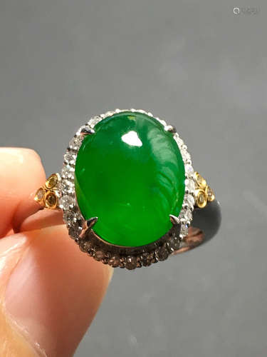 A GREEN JADEITE CARVED CIRCLE FINGER RING