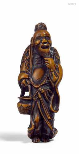 NETSUKE: SENNIN MIT KORB. Japan. Edo-Zeit. 18./19. Jh. Buchsbaum, fein geschnitzt und mit dunkel