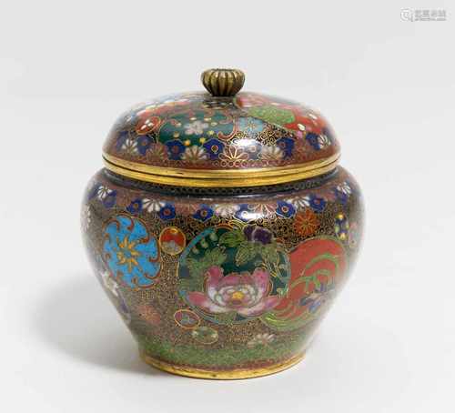 KLEINES DECKELGEFÄß MIT MEDAILLONS UND BLÜTENDEKOR. Japan. 19. Jh. Cloisonné. H. 8,5cm. Im Boden