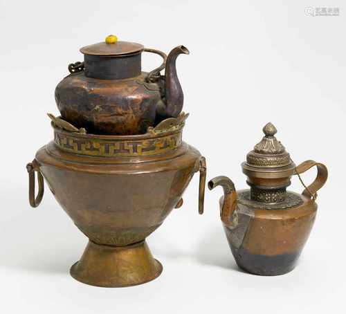 OFEN MIT ZWEI KANNEN FÜR TEE UND WASSER. Tibet. 19. Jh. Kupfer, gehämmert. Teils mit Bronzedekor.