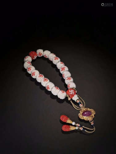 A BRACELET MADE OF WHITE PEARLS AND RED CORAL BEADS