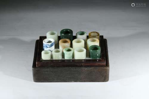 A GROUP OF THIRTEEN JADE AND HARDSTONE ARCHER'S RINGS