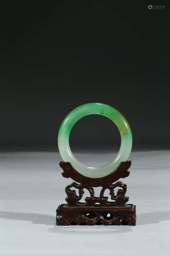 A HARDSTONE CARVED BANGLE WITH STAND