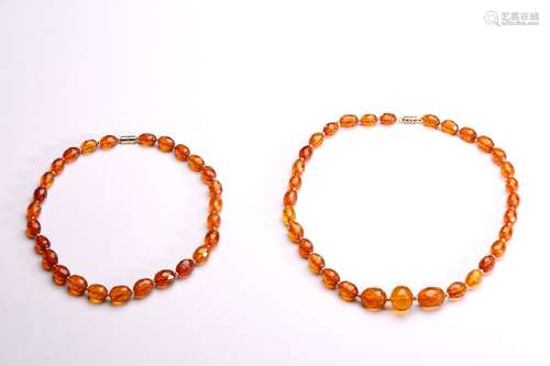 A GROUP OF TWO CARVED AMBER BRACELETS