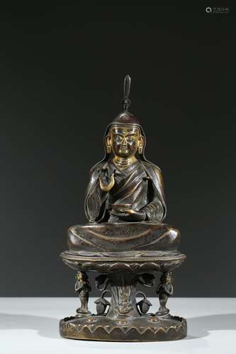 A COLD-GILT BRONZE FIGURE OF SEATED LAMA