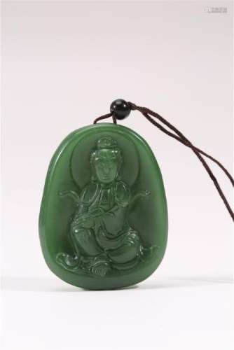 A CARVED SPINACH-GREEN JADE GUANYIN PENDANT.