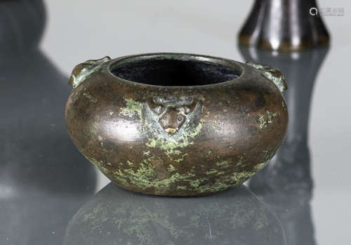 A PARTLY GREEN PATINATED CIRCULAR BRONZE CENSER WITH THREE ANIMAL HEADS