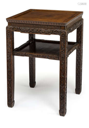 A SMALL TABLE WITH CARVED DECORATION