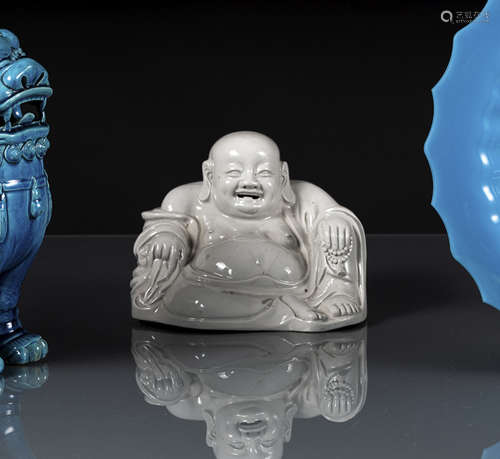 A WHITE GLAZED PORCELAIN MODEL OF SEATED BUDAI