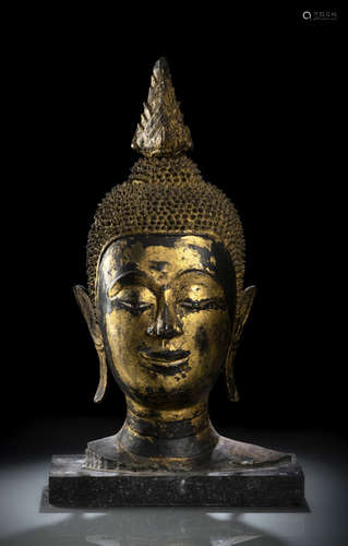 A GILT- AND BLACK-LACQUERED BRONZE HEAD OF BUDDHA SHAKYAMUNI