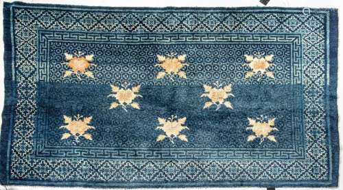 Tapis de laine bleue à décor de feuillages ocre et…