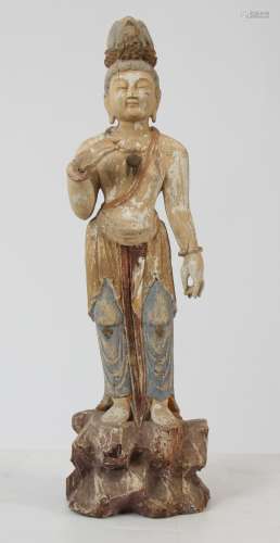 Le Boddhisattva Kwan Yin figuré debout sur un rocher, vêtu de la robe monastique et [...]