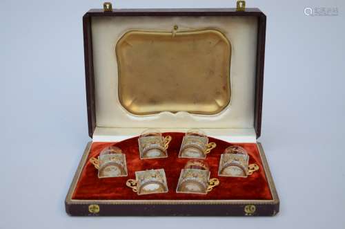 A case containing six enameled cups on a tray