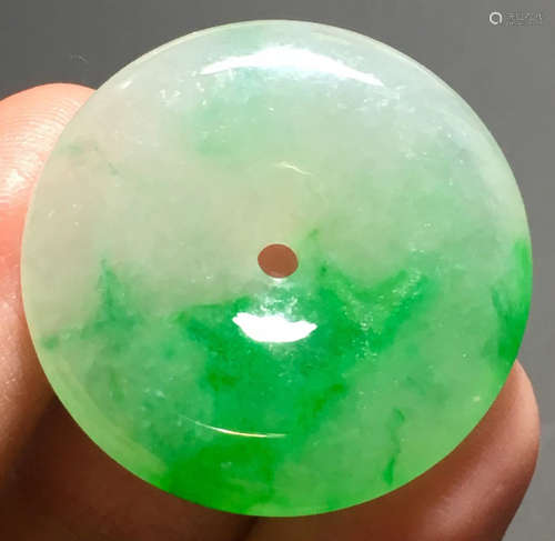 A GREEN JADEITE CARVED CIRCLE PENDANT, TYPE A