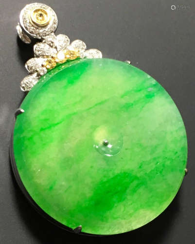 A GREEN JADEITE CARVED CIRCLE PENDANT, TYPE A