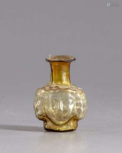 A Roman head glass flask