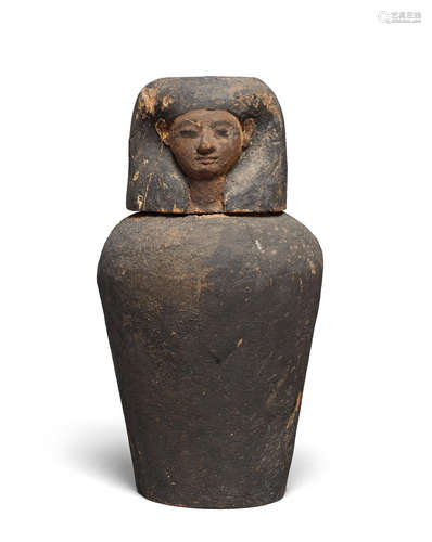 An Egyptian wood canopic jar with stopper