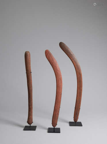 A pair of boomerangs, Yuendumu and a club, Western Desert, Northern Territory, 1920s-1930s lengths: 62.0cm (24 7/16in)., 64.0cm (25 3/16in)., 74.0cm (29 1/8in).  Maker Unknown