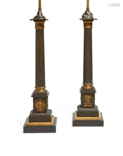 A pair of Empire style gilt and patinated bronze columnar  lamps