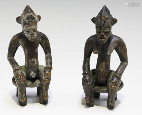 A pair of African carved wooden male and female figures, probably Senufo, both modelled with