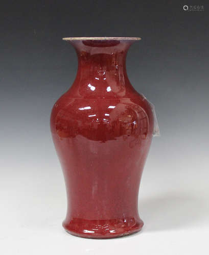 A Chinese sang-de-boeuf glazed porcelain vase, Qing dynasty, of baluster form with flared neck,